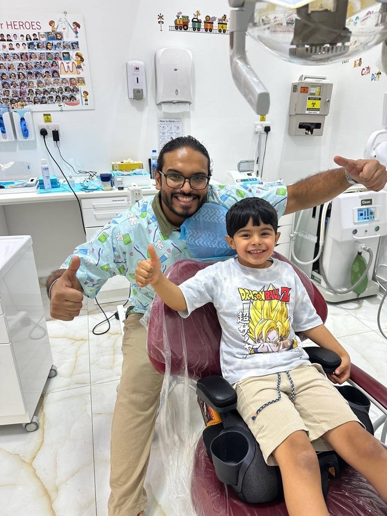 Dr. Mohsen Alozaibi with young patient at Tiny Teeth Dental Center